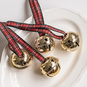 Set of four gold Christmas bells with star cutouts and festive plaid ribbon ties
