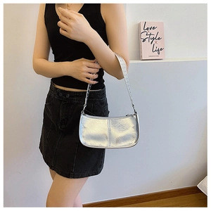 Detail of silver metallic PU shoulder bag with punk rivet texture and shiny surface