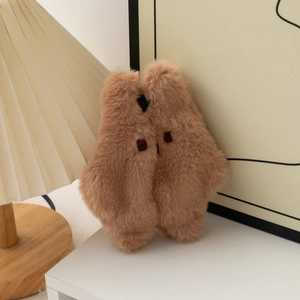 Gros plan d'une pochette ours en peluche marron doux avec broderie et décor chaleureux