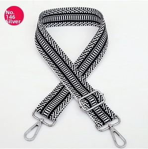 Dettaglio tracolla regolabile in nylon bianco e nero con hardware in metallo argento