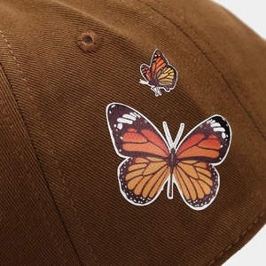 Close-up of brown twill cotton baseball cap featuring detailed butterfly embroidery