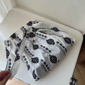 Close-up of ethnic style cotton linen tote bag with black floral embroidery pattern