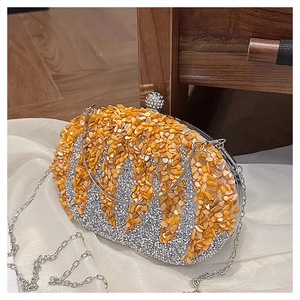 Detail of silver rhinestone evening bag with orange shell fragments and ball clasp