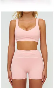 Detail of peach pink ribbed yoga set with white contrast stitching and U-neck sports bra