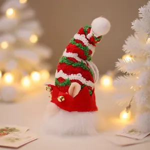 Lighted Christmas gnome ornament with red green knit hat and gold bells on festive tree
