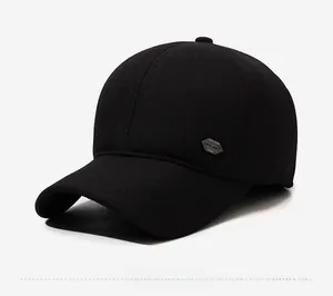 Close-up of black wool winter baseball cap with ear flaps and retro metal logo badge