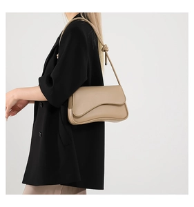 Beige faux leather shoulder bag styled with a black blazer for a minimalist fashion look