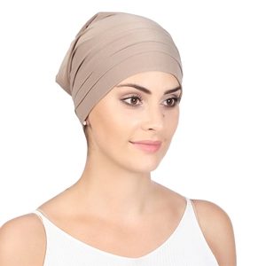 Detailed view of beige pleated headscarf with elastic fabric texture on a model