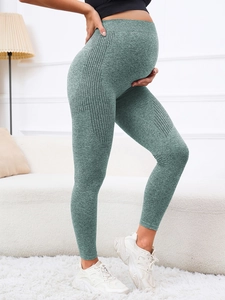 Detail view of maternity yoga leggings in sage green with breathable mesh cutouts