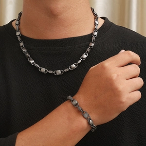 Detail of 8mm geometric knotted chain links on a dark vacuum-plated steel necklace