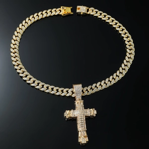 Macro shot of gold Cuban link chain with a large iced-out cross pendant and box clasp