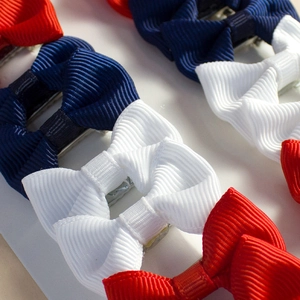 Detailed macro view of handmade grosgrain ribbon bows on duckbill hair clips for girls