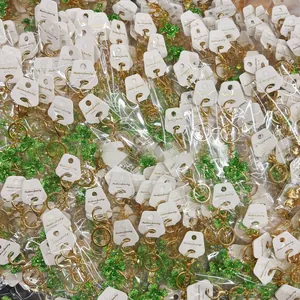 Close-up of green clover keychains with gold metal rings in individual card packaging