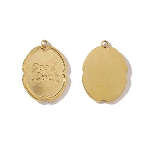 Vue détaillée d'un pendentif doré en acier avec gravure Good Luck et finition martelée