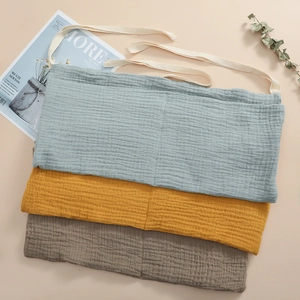 Detail of stacked cotton crib organizers in blue, yellow and grey with soft texture