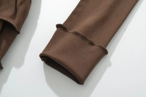 Macro shot of brown knit fabric showing cuff details and ribbed texture of the short dress