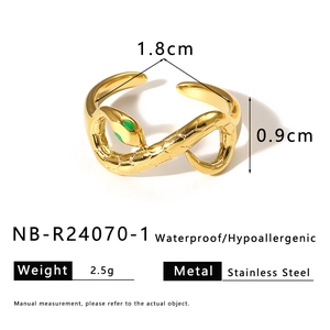 Macro detail of gold plated snake ring with green stone eyes and carved texture details