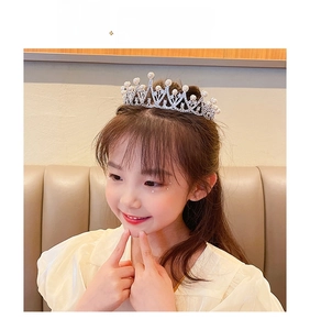 Detail of silver crown headband with pearls and sparkling crystals on a young girl