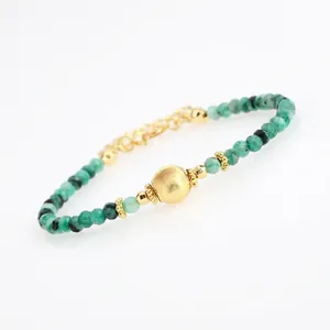 Detail of faceted green gemstone beads and textured gold bead with adjustable chain