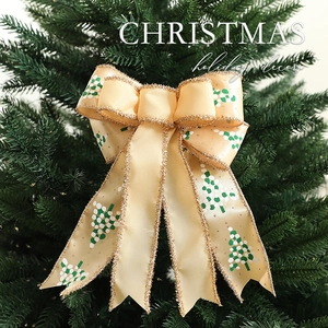 Champagne gold Christmas bow with dot-patterned trees on green pine branches