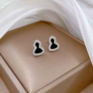 Close-up of titanium steel gourd studs with black enamel and sparkling pavé crystals