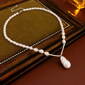 Baroque pearl pendant necklace with white pearls on a green velvet vintage frame display