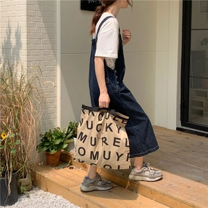 Outdoor-Aufnahme einer großen Canvas-Tragetasche mit markanten schwarzen Buchstaben