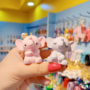Cute resin flying elephant keychains with golden crowns and pearls in pink and gray