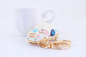 Detailed view of car keychain with white enamel and colorful sparkling rhinestones