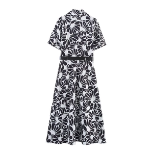 Back view of a halter neck split maxi dress with large black and white floral print and belt