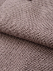 Gros plan sur la maille côtelée taupe montrant la texture douce et les finitions soignées