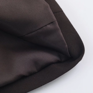 Gros plan sur le tissu sergé marron foncé avec coutures précises et doublure lisse