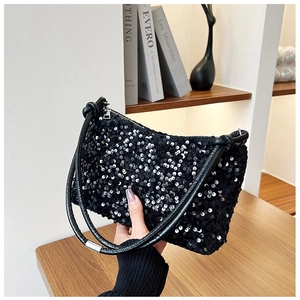 Detail of black sequin baguette bag showing shimmering texture and silver metal hardware