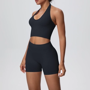 Detail of black halter neck sports bra and high-waist shorts set on a fit model