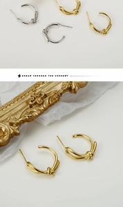 Dettaglio di eleganti orecchini a perno con nodo intrecciato in oro e argento su bianco
