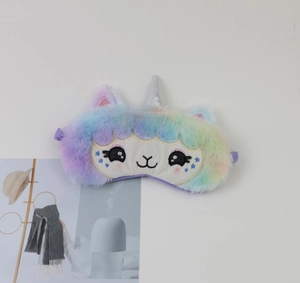 Close-up of a colorful plush unicorn sleep mask with soft embroidery and silver horn detail