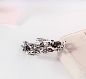 Macro detail of the vintage silver skull palm brooch with red rhinestones and secure pin