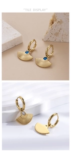 Macro view of gold stainless steel fan-shaped earrings with inlaid zircon and textured finish