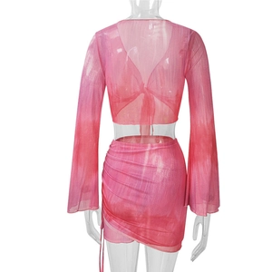 Rear view of tie-dye mesh crop top with flared sleeves and drawstring ruched skirt set