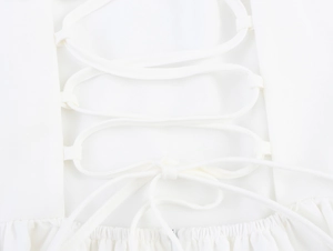 Detailed view of the white fabric with adjustable tie-up shoulder straps and smooth texture