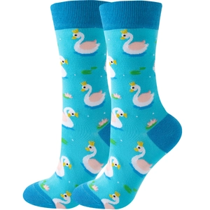 Detail of blue knitted crew socks featuring elegant swan patterns and lily pads