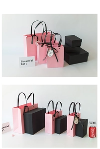 Three sizes of pink gift bags and black gift boxes with black satin handles and tags
