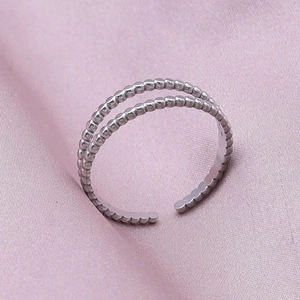 Detail of double-row beaded texture stainless steel open ring on pink silk fabric