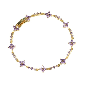 Elegant gold flower bracelet with purple zircon stones on a clean white background