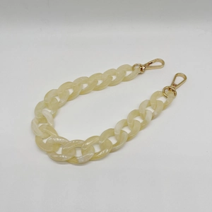 Close-up of cream marbled acrylic chain link with gold metal lobster clasps on ends