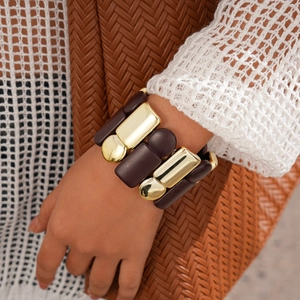 Close-up of a wide chunky acrylic geometric bracelet with gold-tone metal links and resin