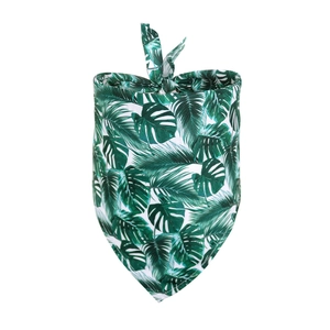 Detail showing tropical green leaf pattern and soft fabric texture of the pet bandana