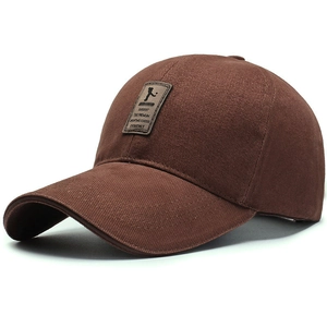 Détail d'une casquette de baseball en coton marron avec écusson en cuir et bord incurvé