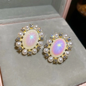 Close-up of vintage oval opal earrings with white pearls and sparkling rhinestones