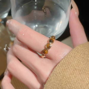 Gros plan d'une bague plaquée or sertie de quatre pierres oeil de tigre rondes